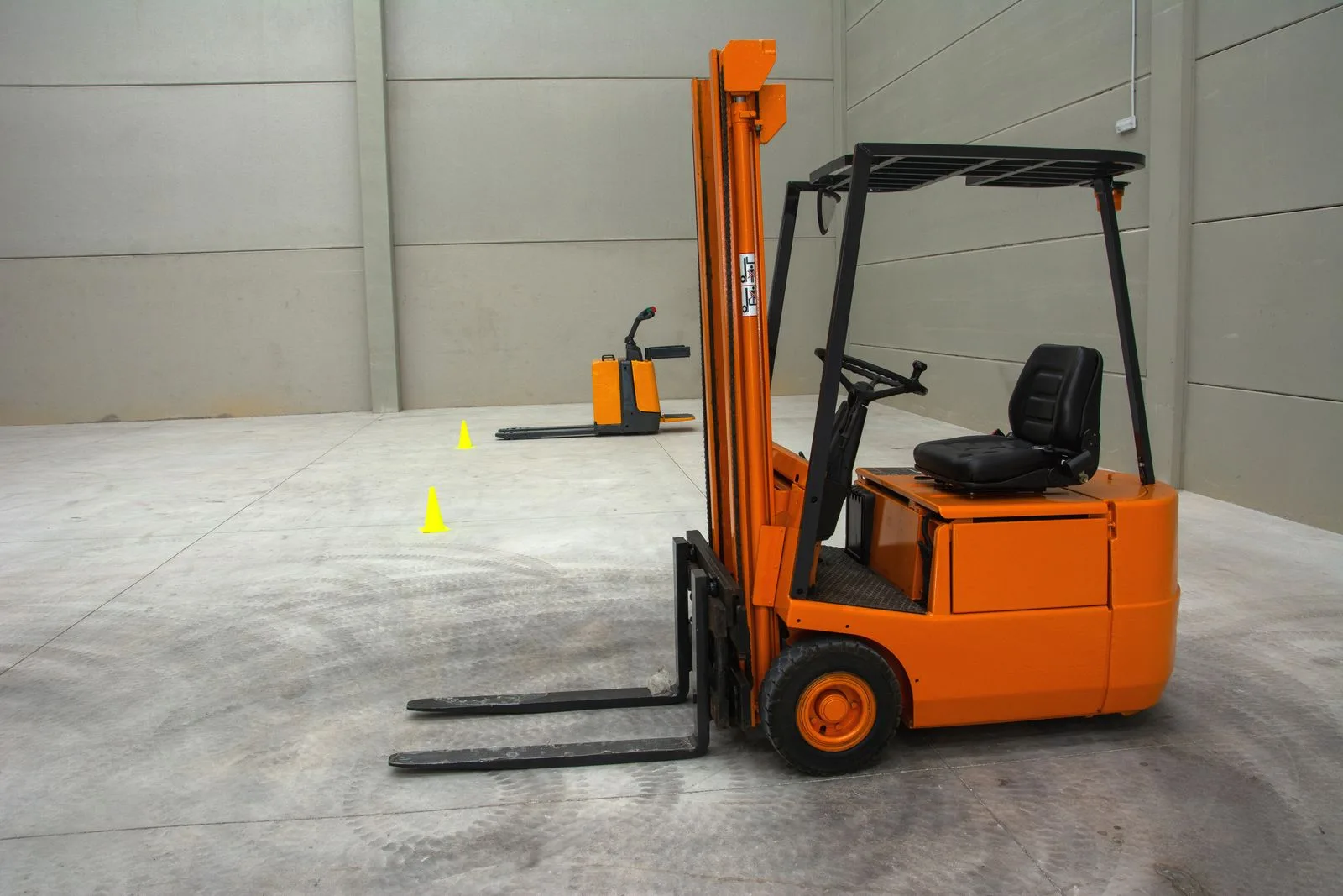 A clean warehouse aisle with racking and a forklift